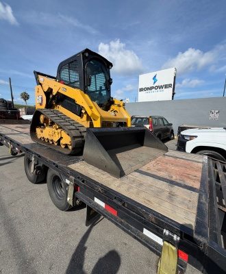 CAT compact track loader on a trailer during an IronPower Industries customer delivery